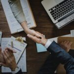 Business professionals shaking hands over company incorporation documents, symbolizing successful business registration and corporate setup services by B-Wiz Partners.
