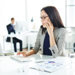 Professional company secretary working at a desk, managing business communications and corporate administration in a modern Singapore office for B-Wiz Partners