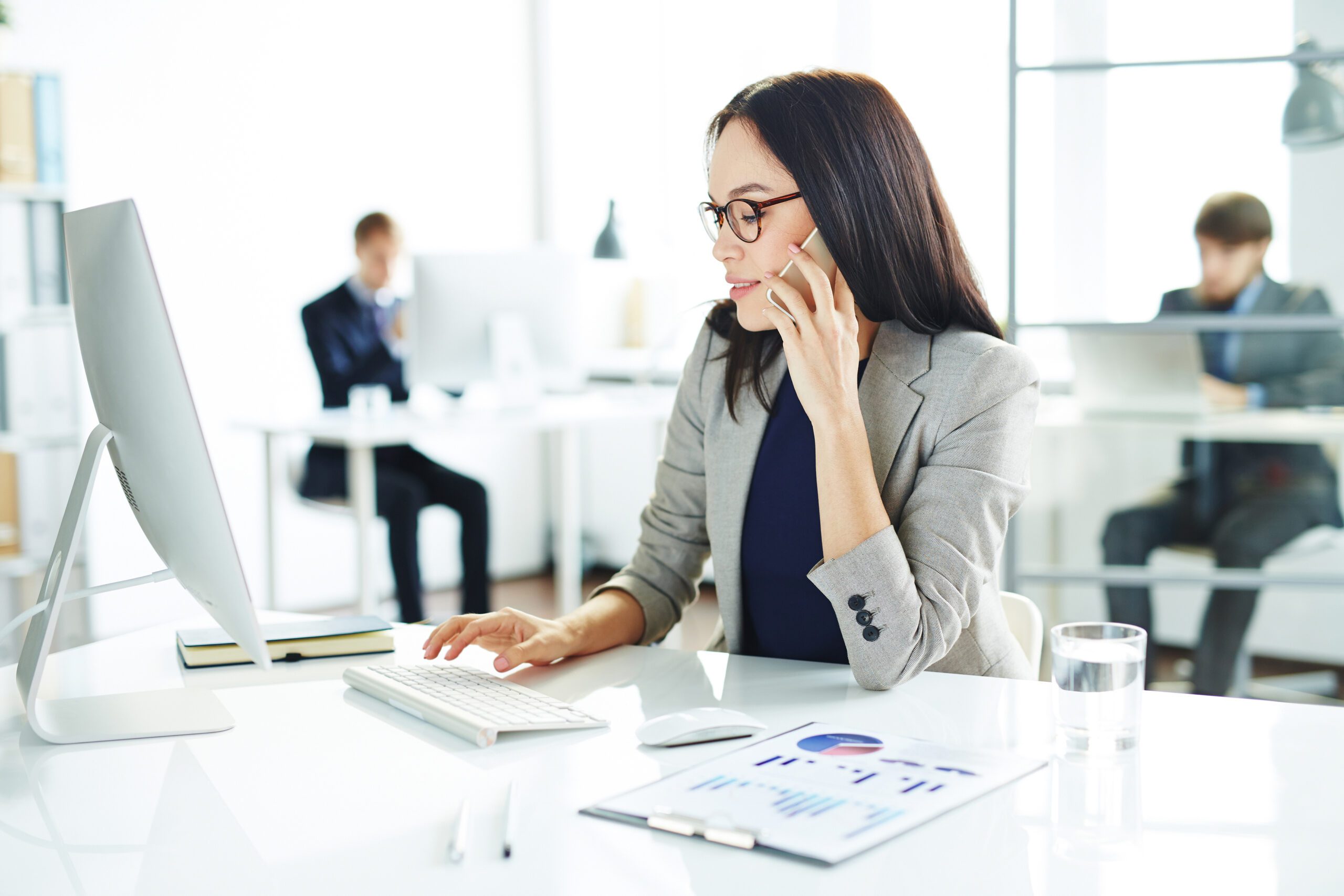 Professional company secretary working at a desk, managing business communications and corporate administration in a modern Singapore office for B-Wiz Partners
