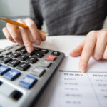 Person calculating small business accounting expenses