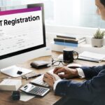 B-Wiz Partners GST registration form displayed on a computer screen while a business professional completes the application.
