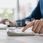 Tax calculation and Double Tax Deduction for Internationalisation (DTDi) concept, showing a professional using a calculator with digital tax icons, for B-Wiz Partners.